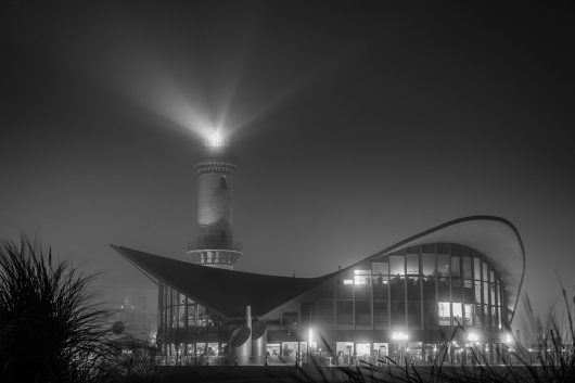 Teepott mit Leuchtturm bei Nacht